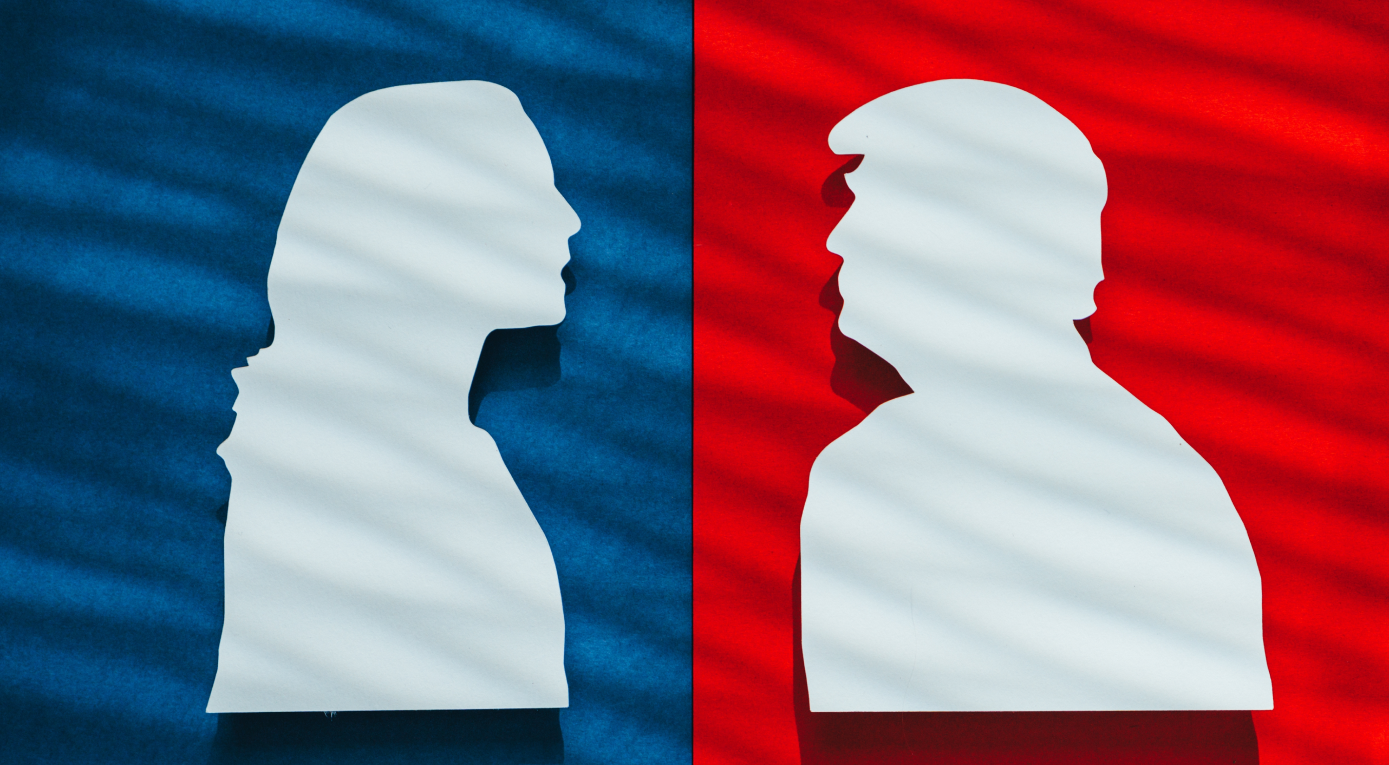 Silhouettes of two political figures facing each other against a split background of blue and red, symbolizing opposing political views or candidates in the U.S. election